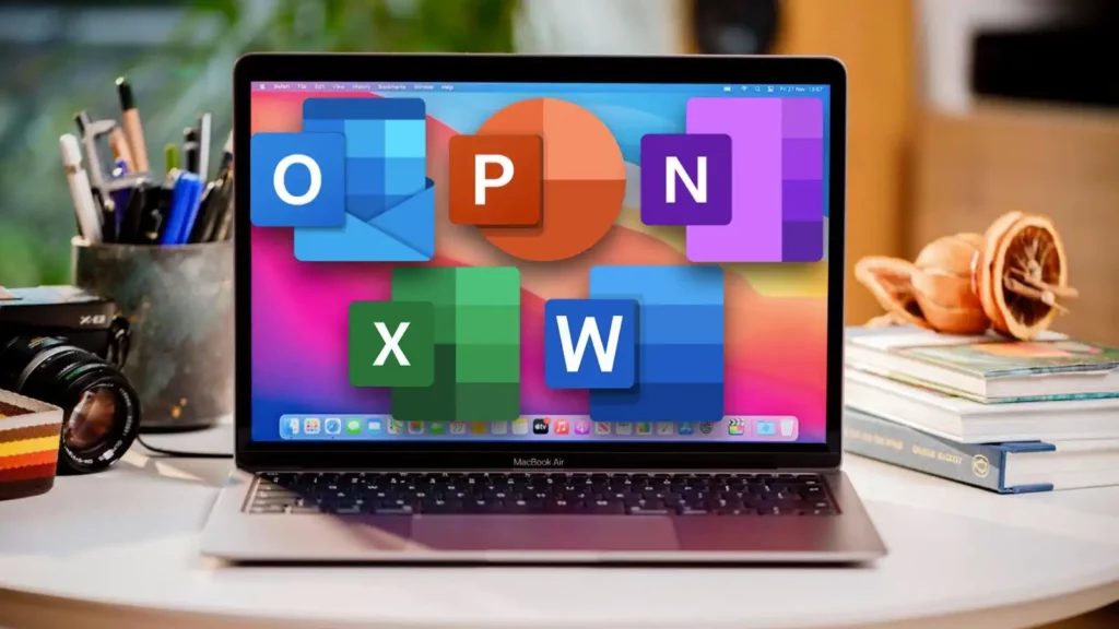 A laptop displays large Microsoft Office app icons—including Outlook, PowerPoint, OneNote, Excel, and Word—on its screen. Perfect for productivity with Office 2019 Home & Business für MAC, it sits on a desk with a camera, notebooks, and a pencil holder.