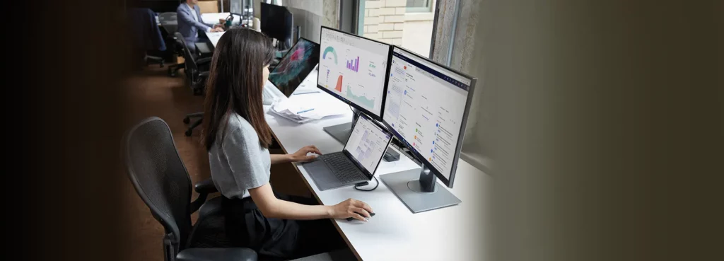 Professionelle Anwenderin mit mehreren Bildschirmen, die Microsoft 365 und Windows 11 Education für Datenanalyse und Produktivität nutzt