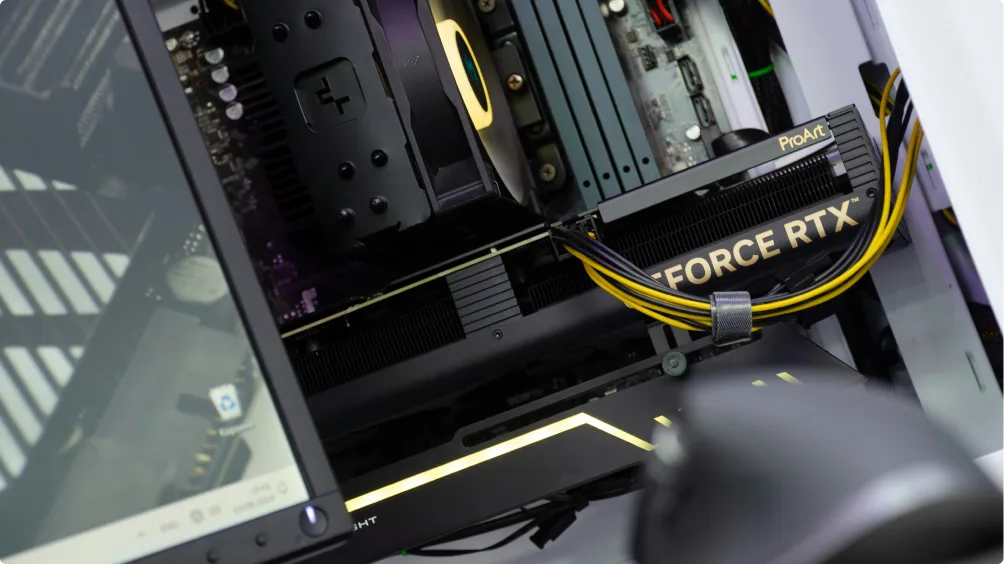 A close-up photo of a desktop computer’s interior showing a GeForce RTX graphics card connected with yellow and black power cables, alongside other components such as the motherboard and RAM.